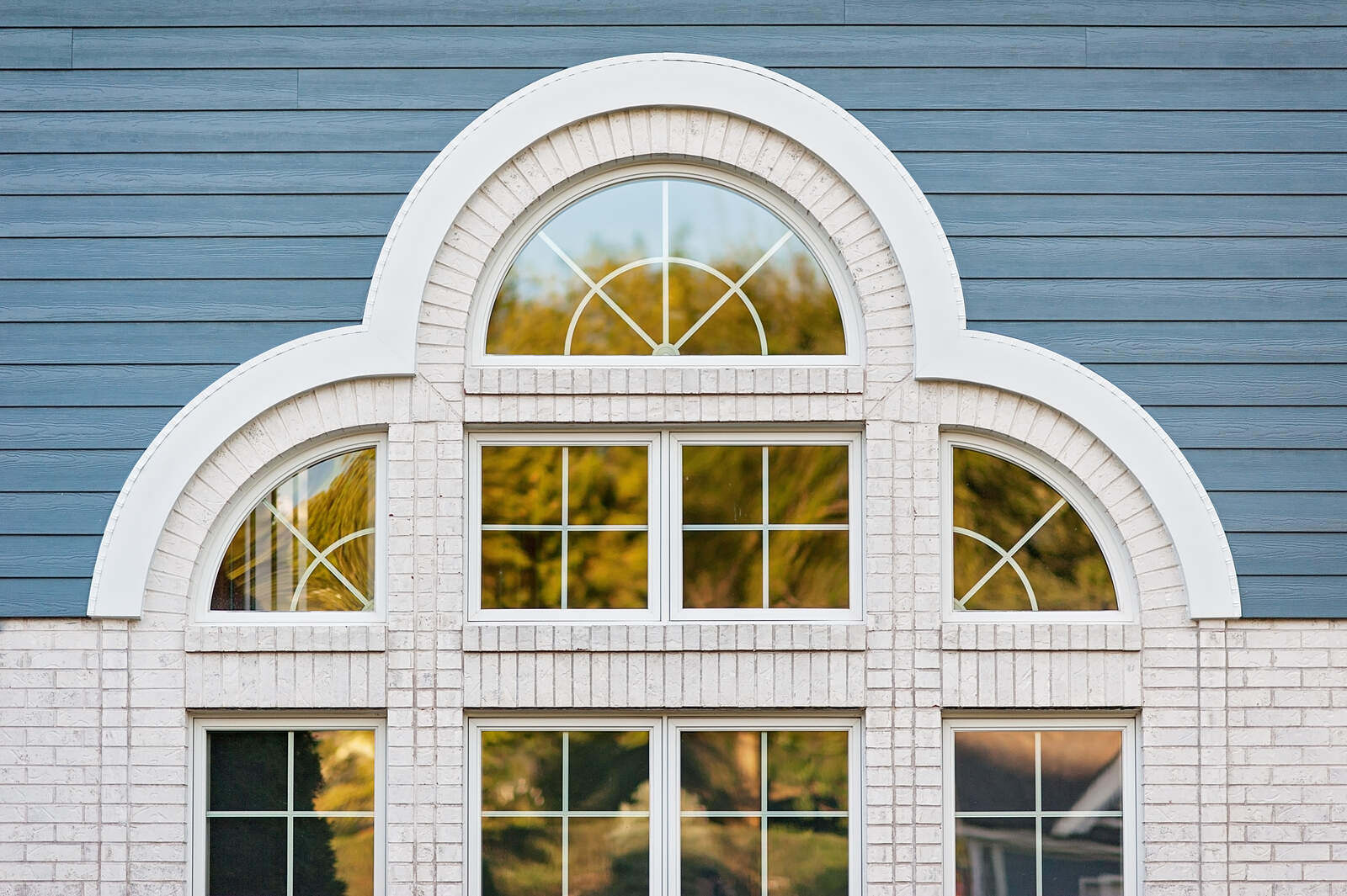 Close-up of a stylish arched window on a blue house remodeled by Smardbuild in Naperville, Chicago