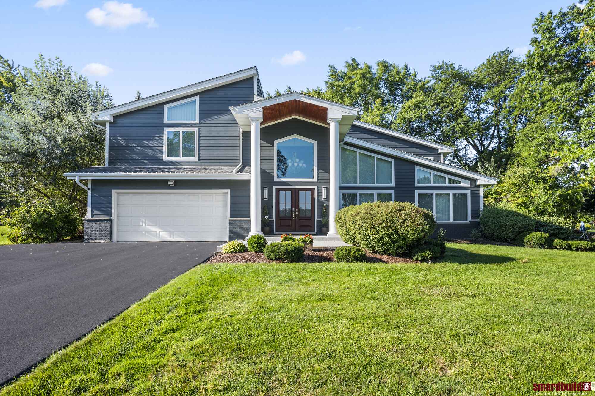 Exterior view of house with white columns and blue siding