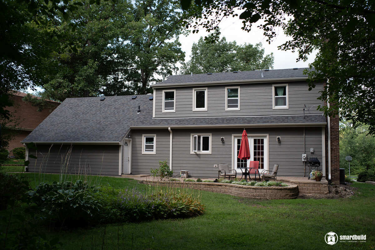 A modern grey house with a spacious backyard and patio area by Smardbuild in Naperville, Chicago