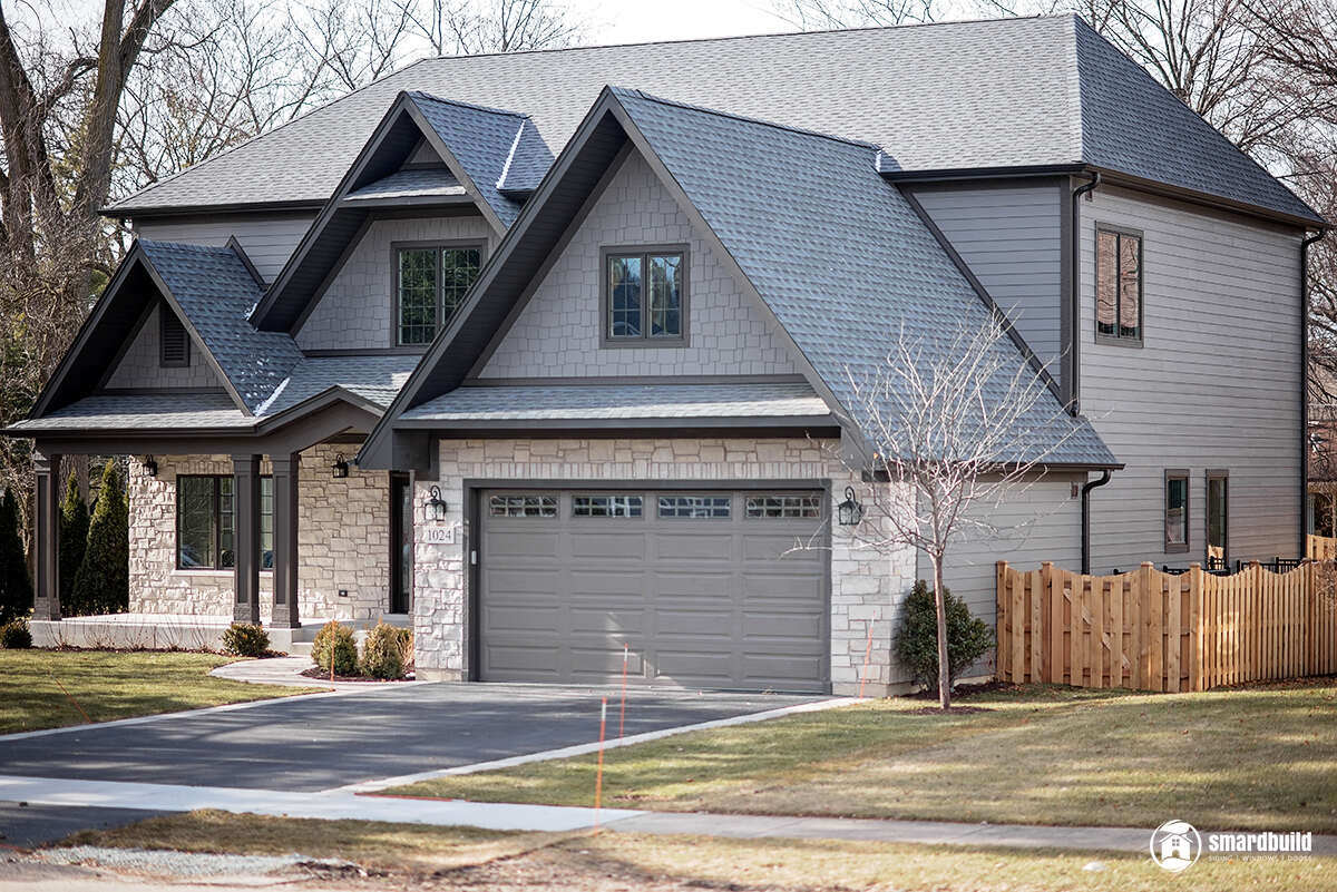 Exterior view of a grey house with stone detailing, renovated by Smardbuild in Naperville, Chicago