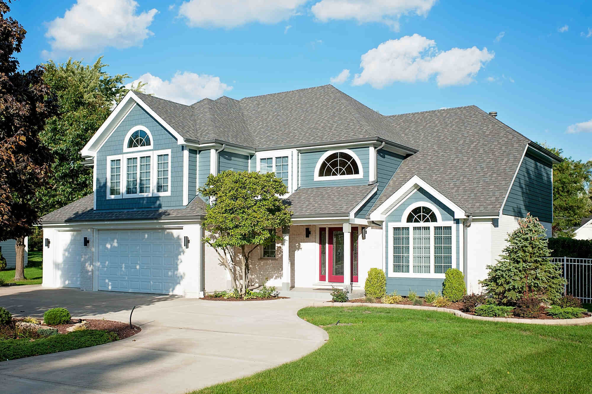 Exterior view of a newly renovated two-story blue house with white trim and a spacious driveway in Naperville, Chicago by Smardbuild (1)