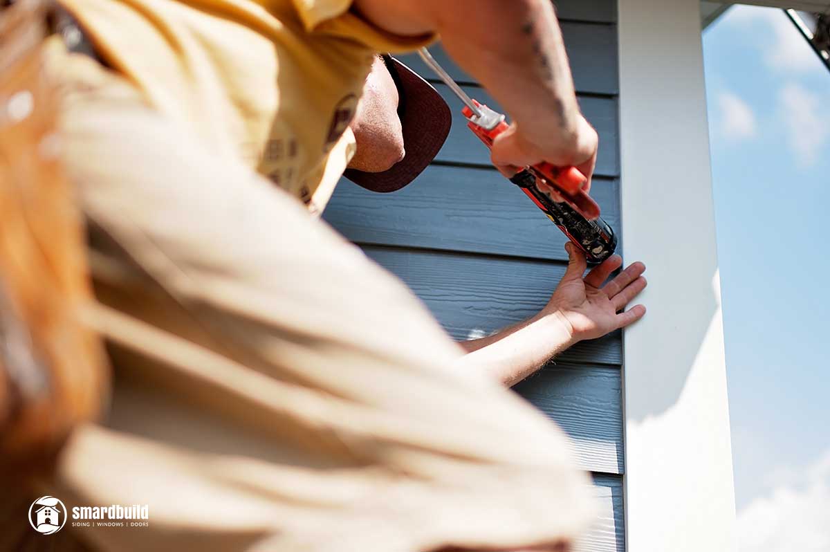 Siding-Installation man caulking window in naperville chicago